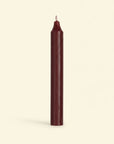 Single burgundy candle on a white background