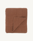 Brown quilted blanket on a white background