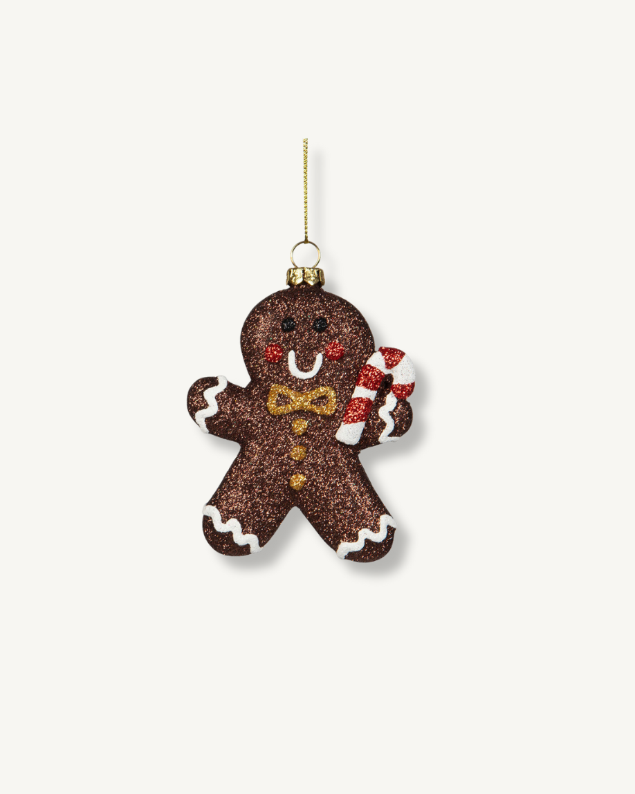 Decorative gingerbread man ornament holding a candy cane on a white background
