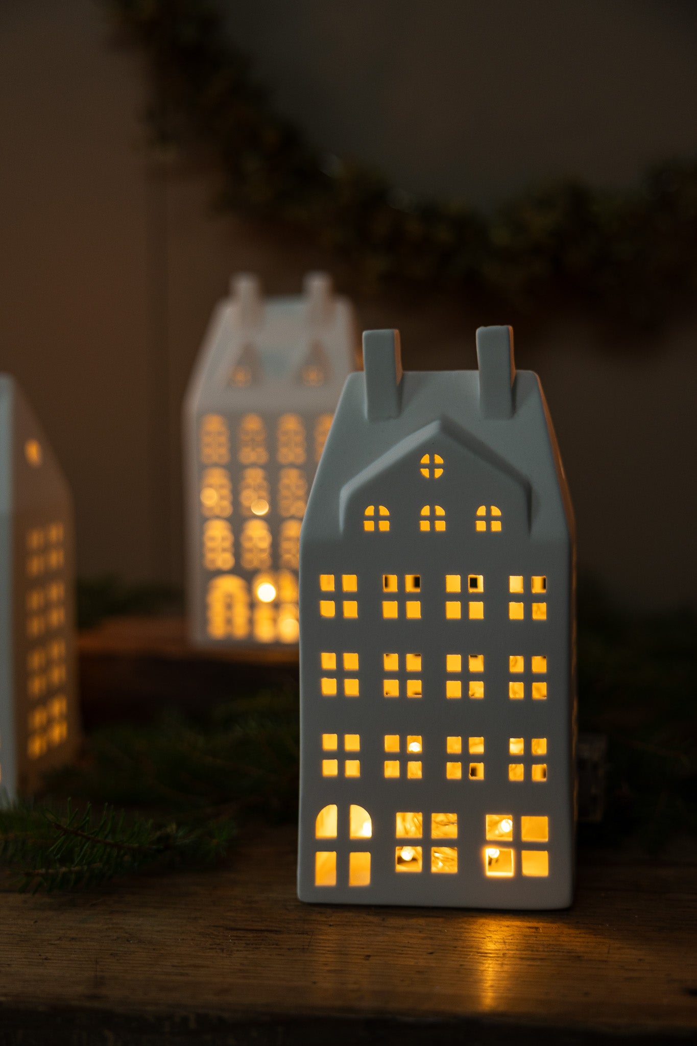 Decorative house-shaped lanterns with warm glow on a dark background