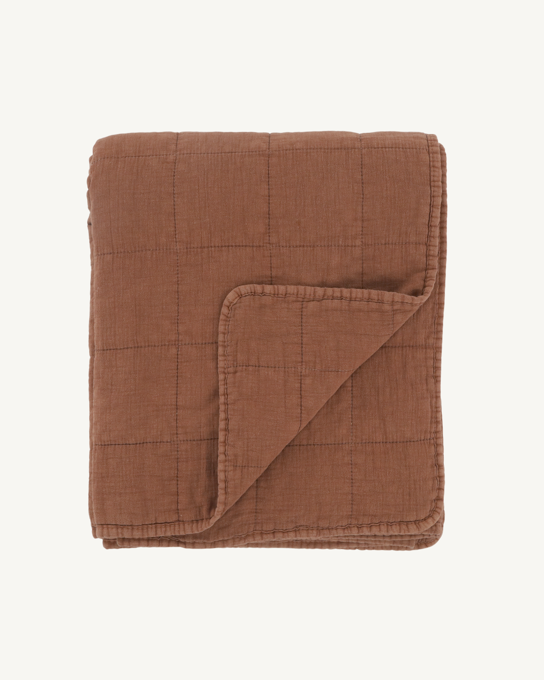 Brown quilted blanket on a white background