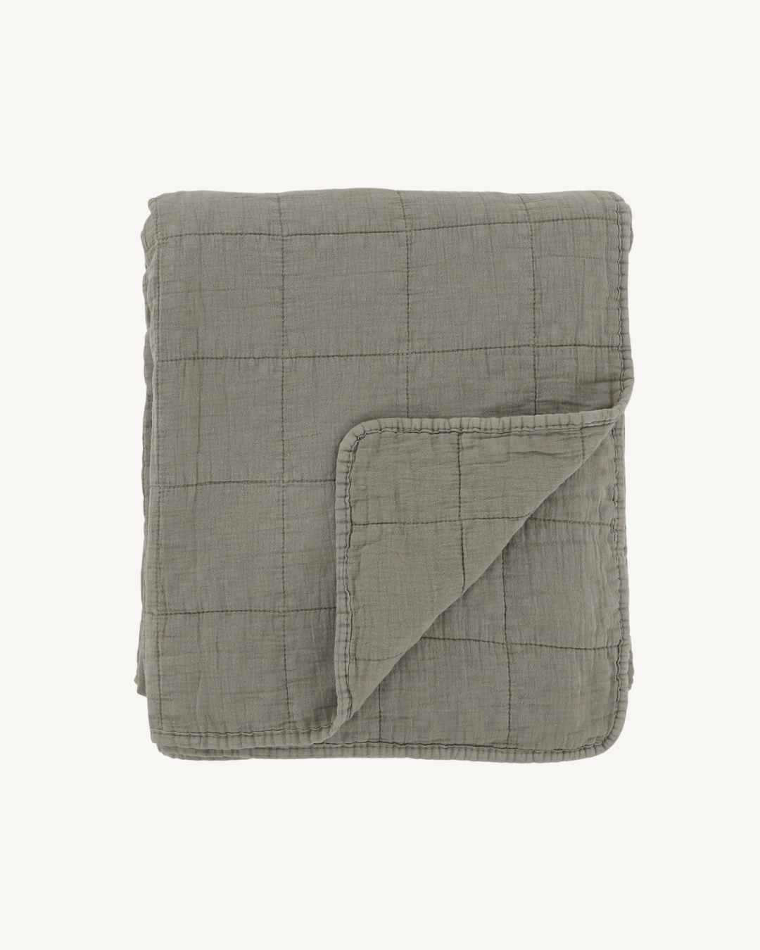 Folded green quilt on a white background