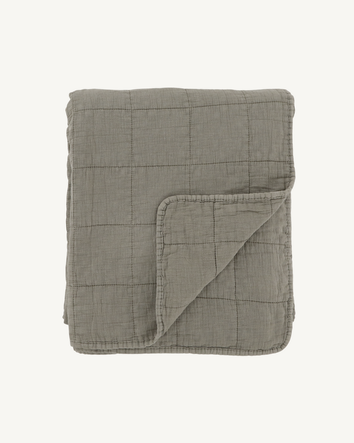 Folded green quilt on a white background