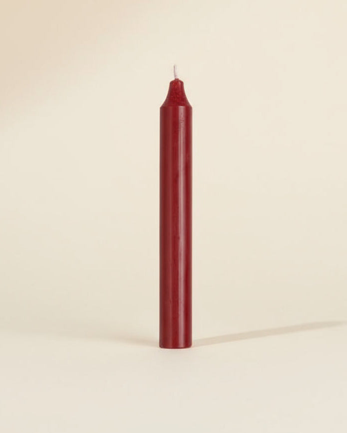 Red candle on a beige background
